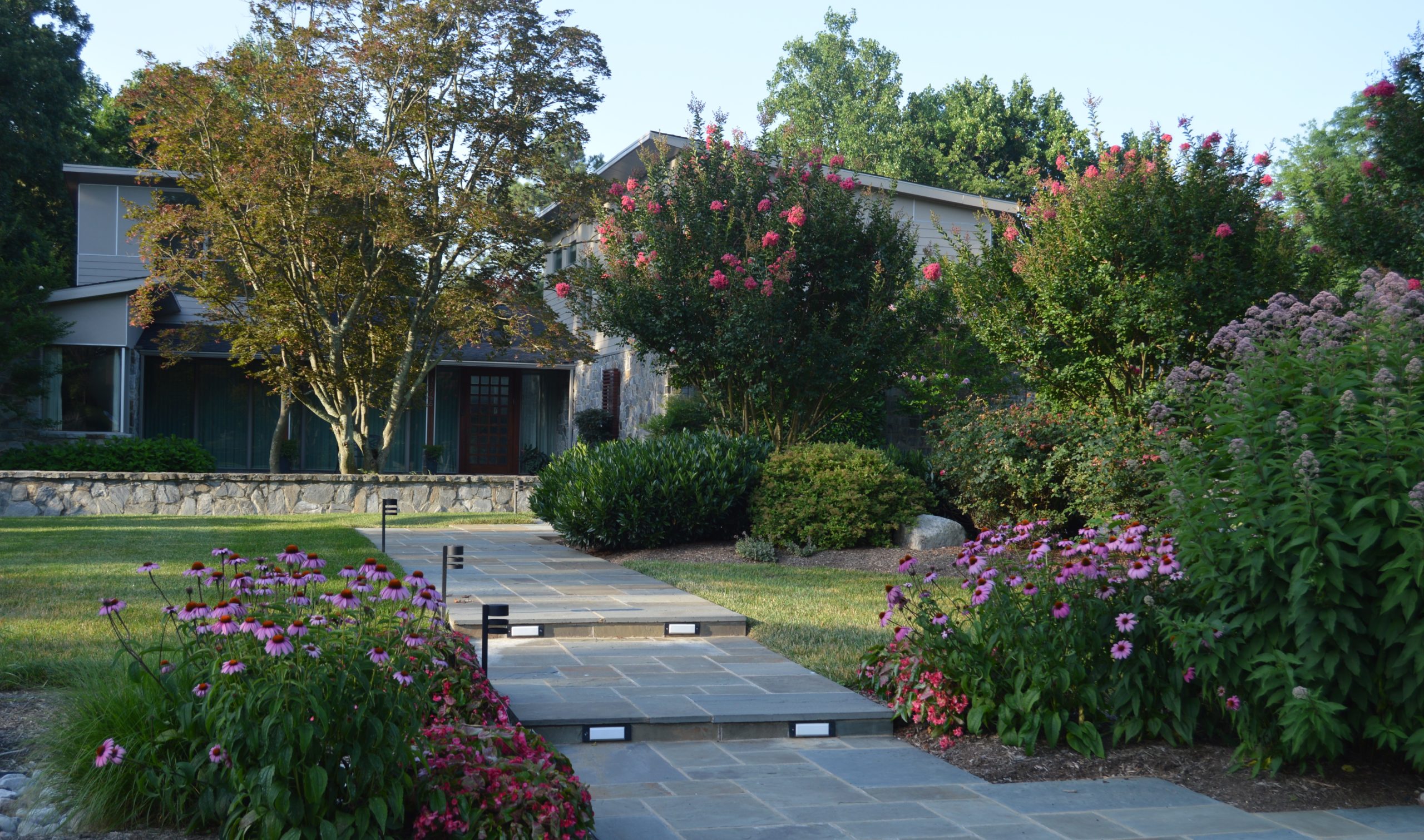 Garden Path installation flanked by colorful flowers on both sides with path lighting