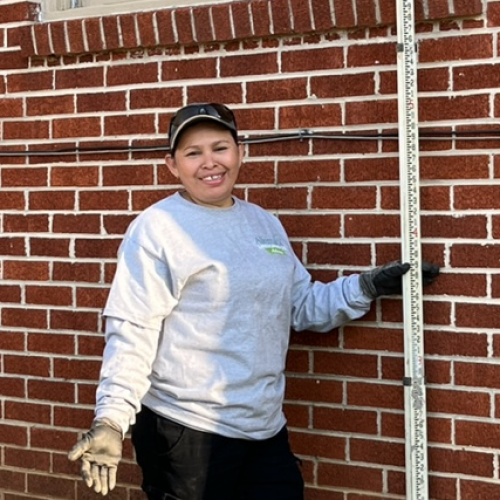 Allentuck Landscaping team member standing by a brick building